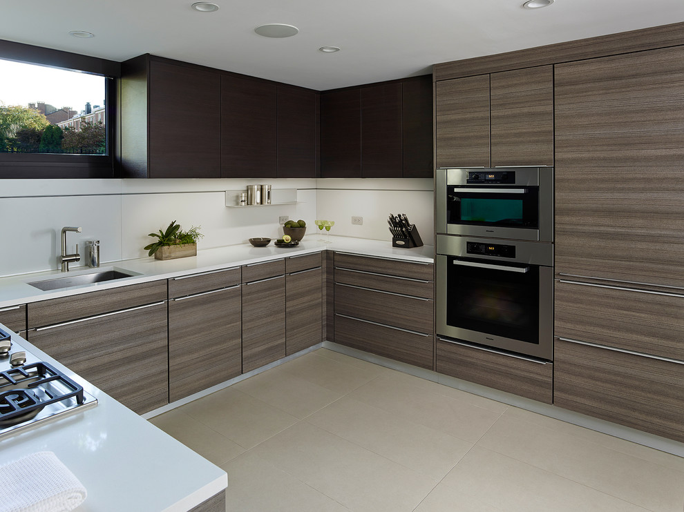 Modelo de cocina moderna con fregadero bajoencimera, armarios con paneles lisos, encimera de cuarzo compacto, electrodomésticos de acero inoxidable y suelo de baldosas de porcelana