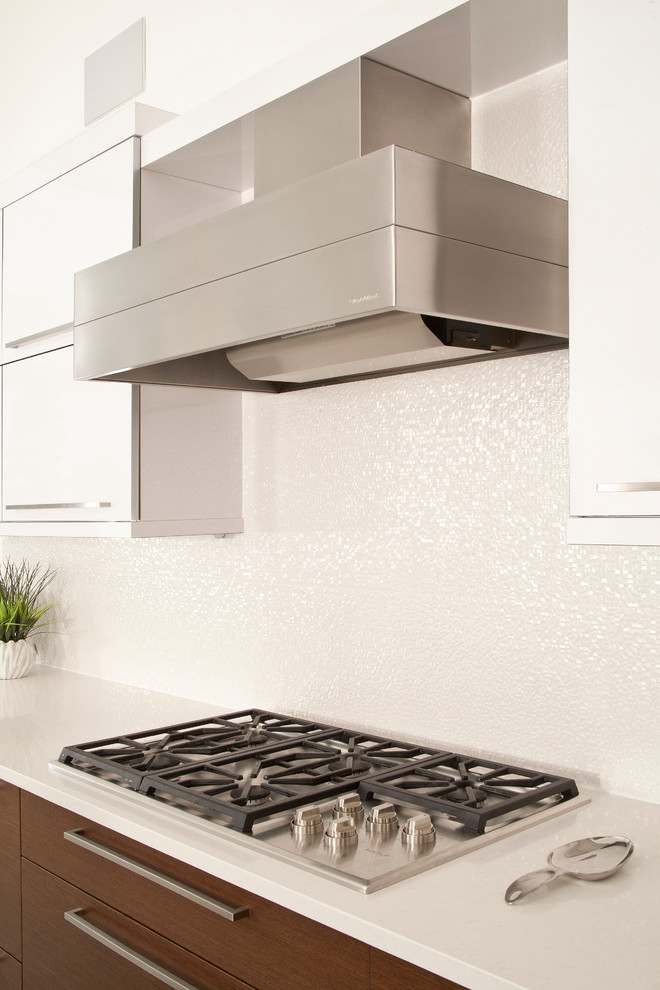 Moderne Küche mit flächenbündigen Schrankfronten, Küchenrückwand in Weiß und Küchengeräten aus Edelstahl in Seattle