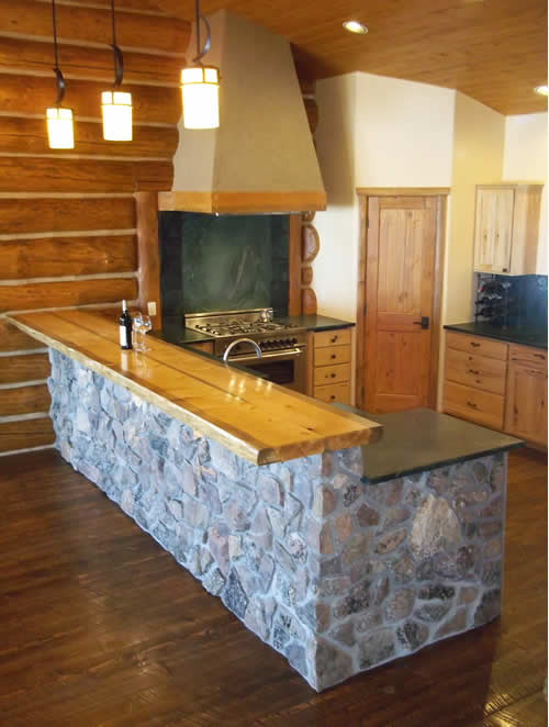Inspiration for a rustic u-shaped eat-in kitchen remodel in Denver with a farmhouse sink, flat-panel cabinets, light wood cabinets, soapstone countertops, black backsplash, stone slab backsplash and stainless steel appliances