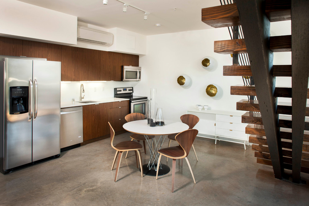 Eat-in kitchen - contemporary single-wall concrete floor eat-in kitchen idea in San Diego with an undermount sink, flat-panel cabinets, dark wood cabinets, stainless steel appliances and no island