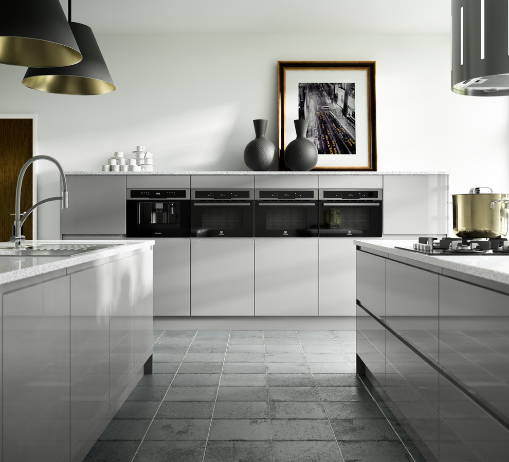 This is an example of a large contemporary single-wall open plan kitchen in Other with a single-bowl sink, flat-panel cabinets, grey cabinets, integrated appliances, cement flooring, multiple islands and grey floors.