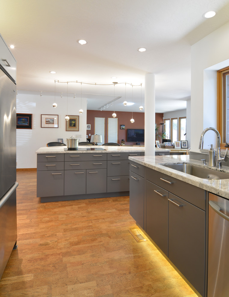Inspiration for a medium sized contemporary galley open plan kitchen in San Luis Obispo with a submerged sink, flat-panel cabinets, grey cabinets, engineered stone countertops, grey splashback, glass tiled splashback, stainless steel appliances, cork flooring, an island, brown floors and grey worktops.