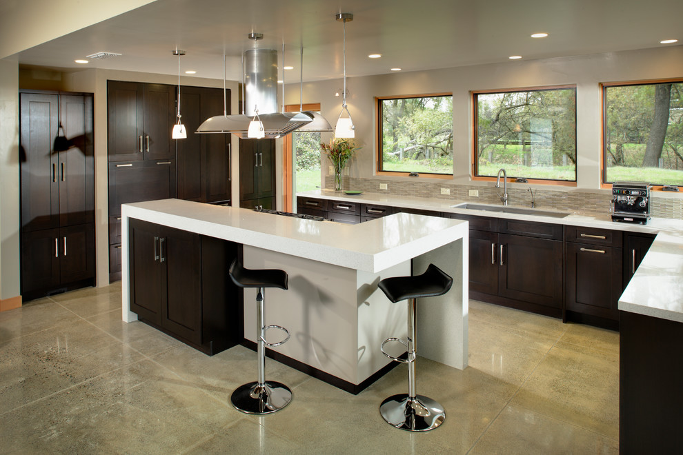 Exempel på ett stort modernt kök, med en trippel diskho, skåp i shakerstil, skåp i mörkt trä, bänkskiva i kvarts, beige stänkskydd, stänkskydd i stickkakel, integrerade vitvaror, betonggolv och en köksö