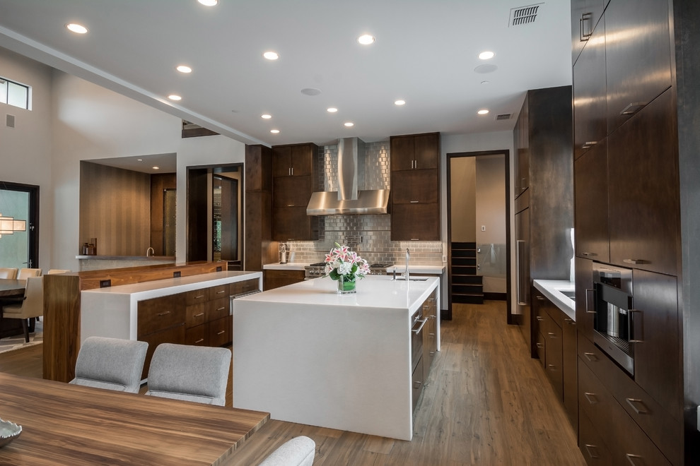 Inspiration for a huge contemporary u-shaped porcelain tile and brown floor open concept kitchen remodel in Orange County with flat-panel cabinets, brown cabinets, marble countertops, metallic backsplash, metal backsplash, stainless steel appliances and two islands