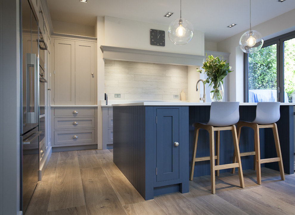 Inspiration for a medium sized scandi l-shaped kitchen/diner in Other with a submerged sink, shaker cabinets, grey cabinets, composite countertops, beige splashback, ceramic splashback, black appliances, ceramic flooring, an island, beige floors and white worktops.