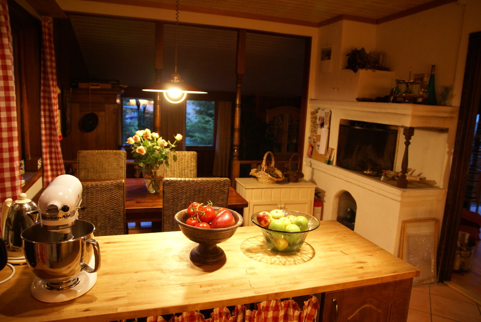 Idéer för ett mellanstort klassiskt l-kök, med en dubbel diskho, luckor med upphöjd panel, skåp i mörkt trä, träbänkskiva, orange stänkskydd, stänkskydd i keramik, svarta vitvaror, klinkergolv i keramik och en köksö