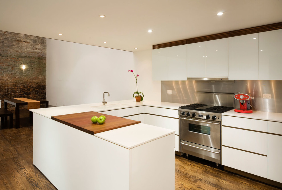 Exempel på ett mellanstort modernt kök, med släta luckor, vita skåp, stänkskydd med metallisk yta, stänkskydd i metallkakel, mellanmörkt trägolv, en halv köksö, en dubbel diskho, bänkskiva i koppar, rostfria vitvaror och brunt golv