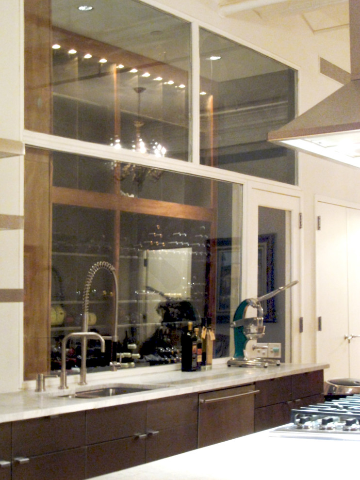 Example of a mid-sized transitional galley medium tone wood floor kitchen design in New York with an undermount sink, flat-panel cabinets, marble countertops, glass sheet backsplash, stainless steel appliances, an island and dark wood cabinets
