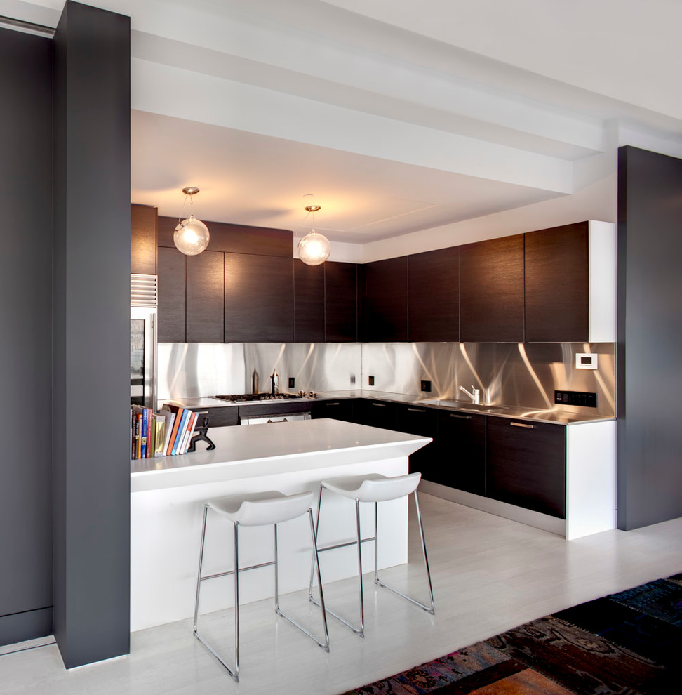 Photo of a medium sized contemporary l-shaped open plan kitchen in New York with a submerged sink, flat-panel cabinets, dark wood cabinets, stainless steel worktops, stainless steel appliances, light hardwood flooring, a breakfast bar and beige floors.