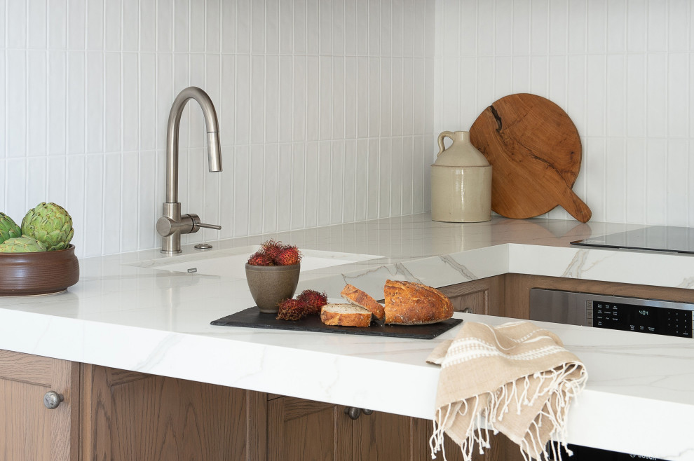 Idée de décoration pour une petite cuisine minimaliste en U et bois brun avec un placard à porte shaker, un plan de travail en quartz modifié, une crédence blanche, une péninsule et un plan de travail blanc.