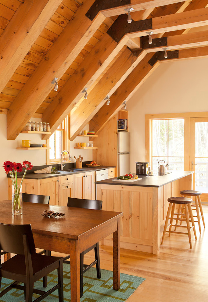 Eat-in kitchen - mid-sized contemporary single-wall medium tone wood floor and exposed beam eat-in kitchen idea in Portland Maine with an undermount sink, shaker cabinets, medium tone wood cabinets, black backsplash, stainless steel appliances, an island and black countertops