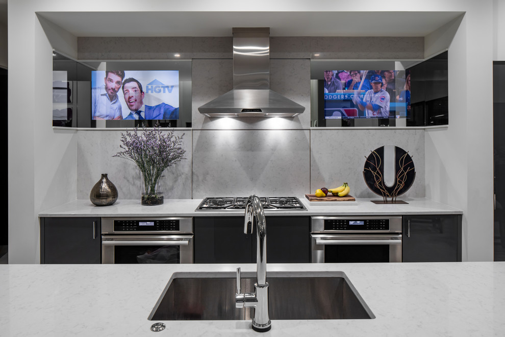 This is an example of an expansive modern galley kitchen/diner in Orlando with a single-bowl sink, flat-panel cabinets, grey cabinets, quartz worktops, grey splashback, stone slab splashback, stainless steel appliances, porcelain flooring, an island, white floors and grey worktops.