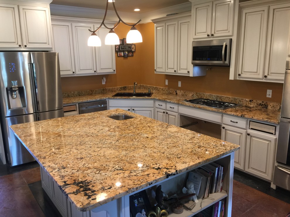 Photo of a medium sized classic l-shaped enclosed kitchen in New Orleans with a submerged sink, raised-panel cabinets, white cabinets, granite worktops, yellow splashback, stone slab splashback, stainless steel appliances, ceramic flooring and an island.