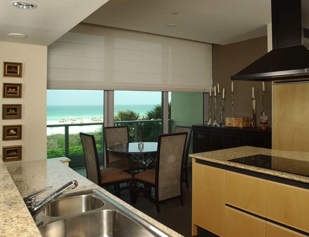 Zweizeilige, Mittelgroße Moderne Wohnküche ohne Insel mit Einbauwaschbecken, flächenbündigen Schrankfronten, hellen Holzschränken, Granit-Arbeitsplatte, Küchengeräten aus Edelstahl, dunklem Holzboden und blauem Boden in Miami