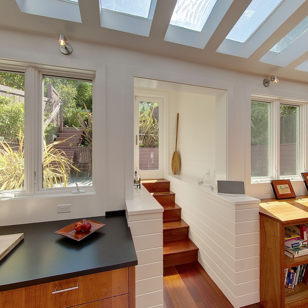 Idées déco pour une cuisine contemporaine en bois brun avec un placard à porte plane et plafond verrière.