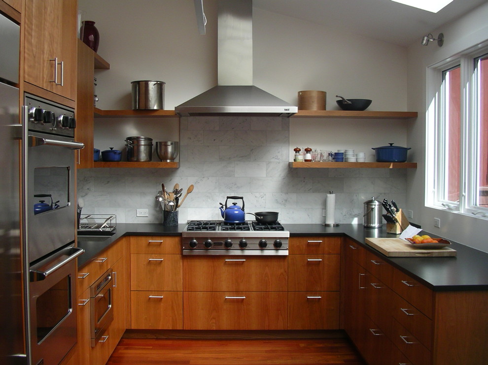 Foto på ett funkis u-kök, med rostfria vitvaror, öppna hyllor, skåp i mellenmörkt trä, vitt stänkskydd och stänkskydd i marmor