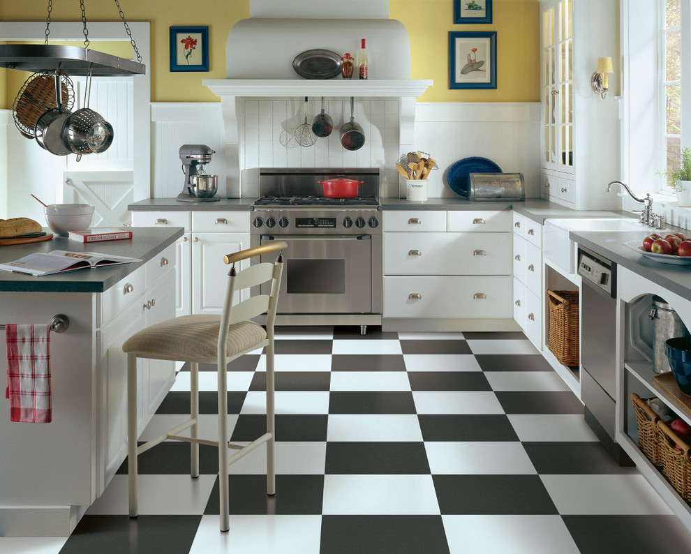 Foto på ett stort lantligt kök, med en rustik diskho, släta luckor, vita skåp, laminatbänkskiva, vitt stänkskydd, stänkskydd i tunnelbanekakel, rostfria vitvaror, vinylgolv och en köksö