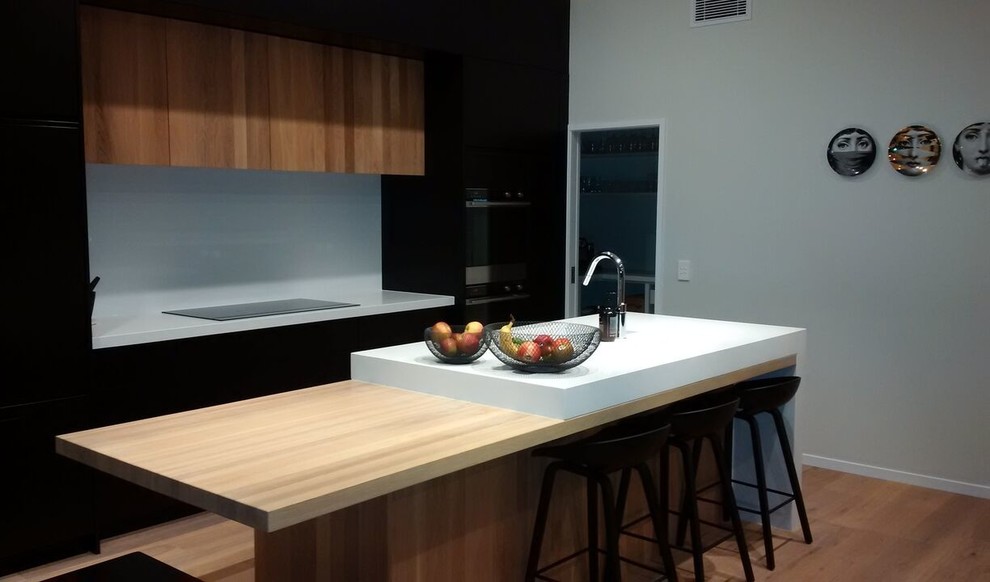 На фото: параллельная кухня среднего размера в стиле модернизм с деревянной столешницей и островом с