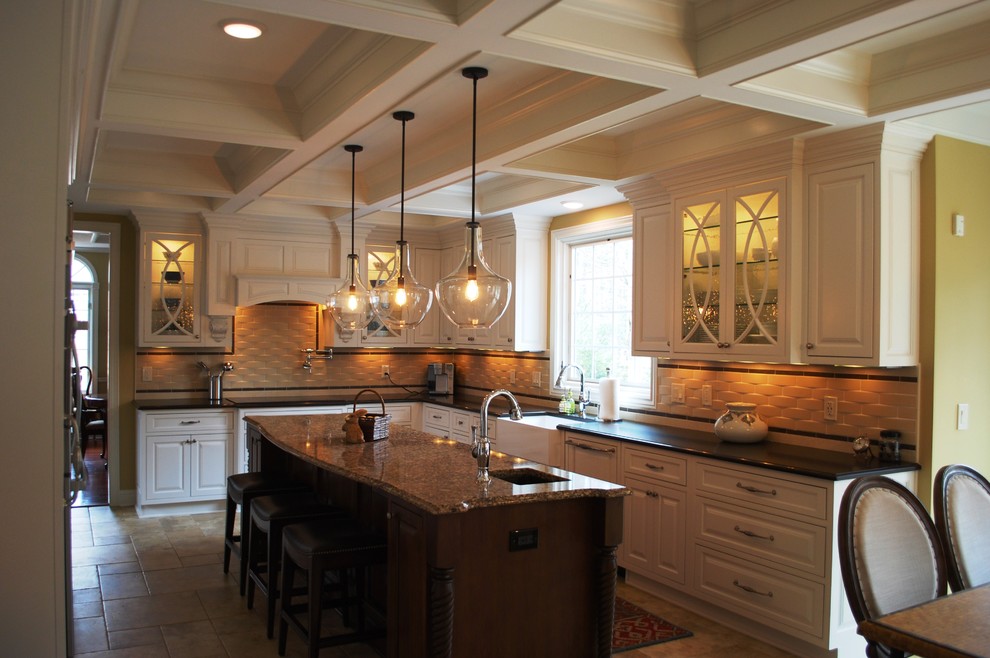 Inspiration for a large timeless u-shaped porcelain tile enclosed kitchen remodel in Cleveland with a farmhouse sink, beaded inset cabinets, white cabinets, quartz countertops, porcelain backsplash, stainless steel appliances and an island