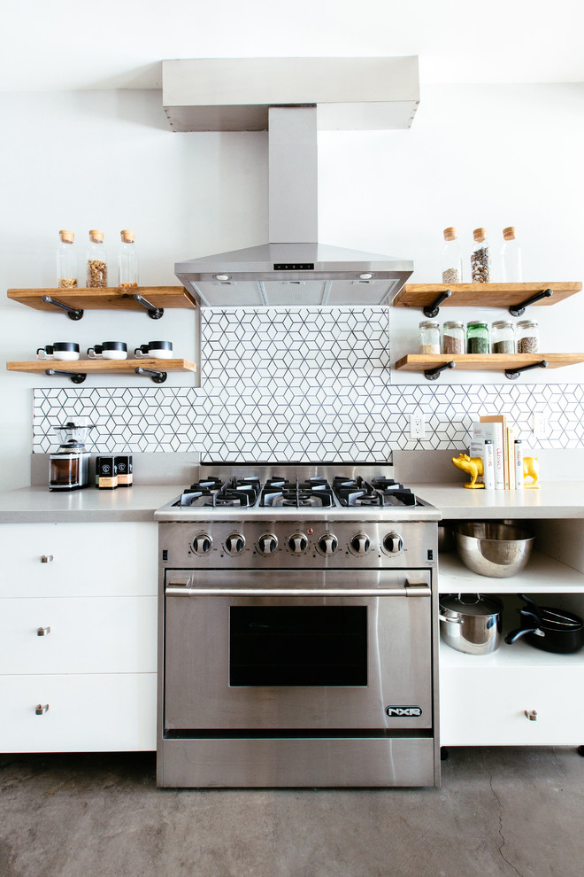 Modern inredning av ett mellanstort kök, med en undermonterad diskho, släta luckor, vita skåp, bänkskiva i kvarts, vitt stänkskydd, stänkskydd i keramik, rostfria vitvaror och betonggolv