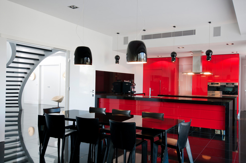 Свежая идея для дизайна: параллельная кухня в современном стиле с обеденным столом, плоскими фасадами, красными фасадами и островом - отличное фото интерьера