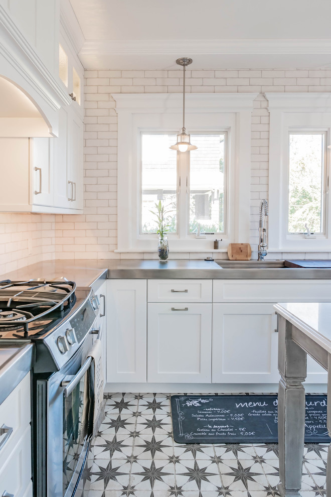 Diseño de cocina de estilo de casa de campo con encimera de acero inoxidable y suelo de baldosas de porcelana