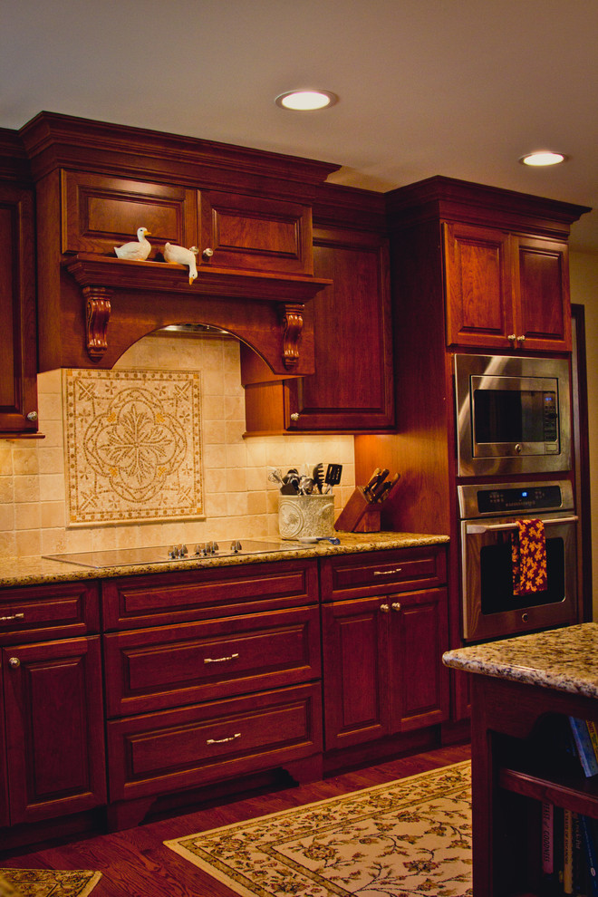 Exempel på ett stort klassiskt kök, med en nedsänkt diskho, luckor med upphöjd panel, skåp i mörkt trä, granitbänkskiva, beige stänkskydd, stänkskydd i stenkakel, rostfria vitvaror, mörkt trägolv och en köksö