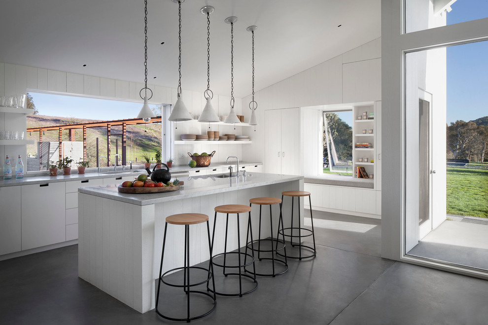 Источник вдохновения для домашнего уюта: кухня в стиле кантри с плоскими фасадами, белыми фасадами, бетонным полом и островом
