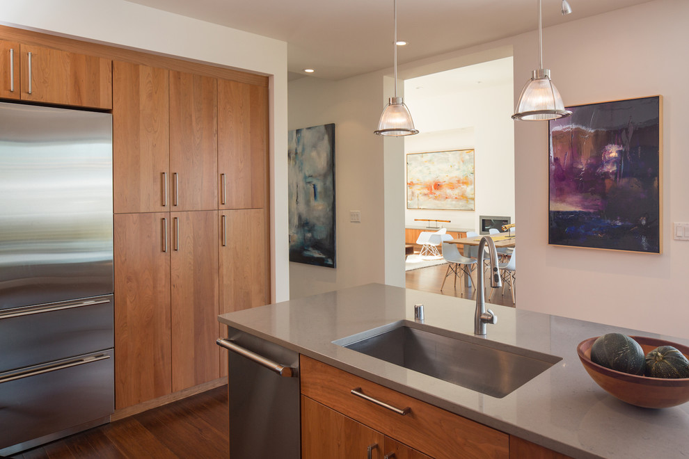 Moderne Küche mit Unterbauwaschbecken, flächenbündigen Schrankfronten, hellbraunen Holzschränken, Küchengeräten aus Edelstahl, dunklem Holzboden und Kücheninsel in San Francisco