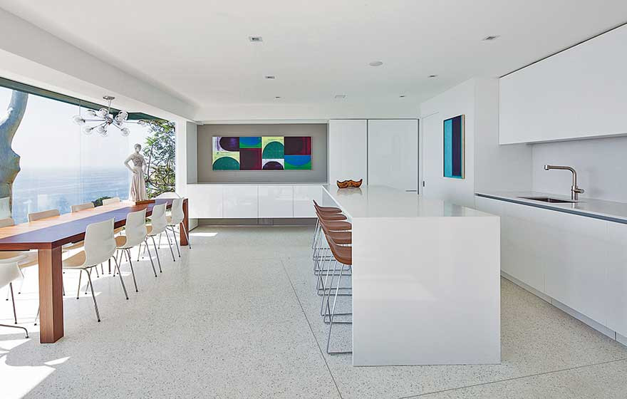 Design ideas for a large contemporary l-shaped kitchen/diner in San Francisco with a single-bowl sink, flat-panel cabinets, white cabinets, engineered stone countertops, white splashback, porcelain splashback, integrated appliances, terrazzo flooring, an island, grey floors and white worktops.