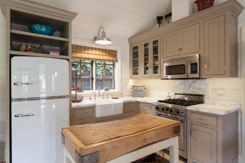 Inspiration for a small country l-shaped kitchen remodel in San Francisco with a farmhouse sink, beaded inset cabinets, stainless steel appliances, an island and beige cabinets
