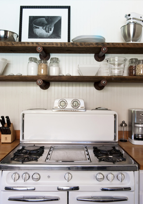Foto på ett mellanstort funkis kök, med en undermonterad diskho, luckor med infälld panel, vita skåp, träbänkskiva, stänkskydd med metallisk yta, stänkskydd i metallkakel, rostfria vitvaror och mörkt trägolv