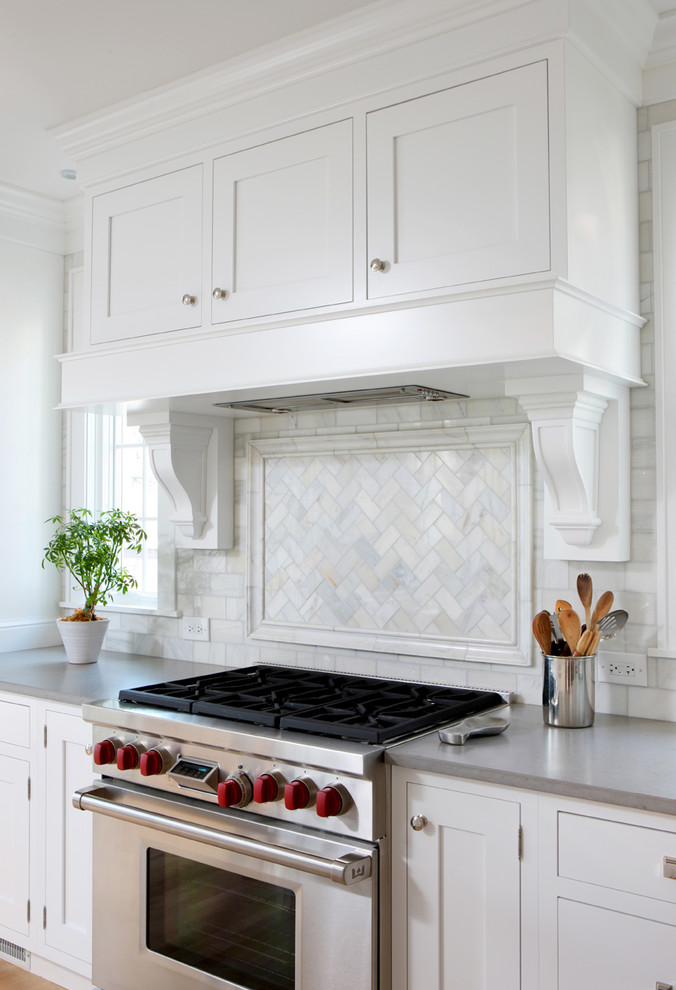 Eat-in kitchen - large transitional galley eat-in kitchen idea in Chicago with shaker cabinets, white cabinets, quartz countertops, gray backsplash, stone tile backsplash, stainless steel appliances and an island