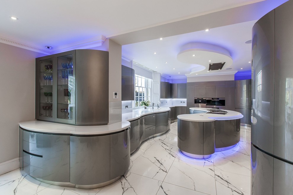 Moderne Küche mit integriertem Waschbecken, flächenbündigen Schrankfronten, grauen Schränken, Mineralwerkstoff-Arbeitsplatte, Küchengeräten aus Edelstahl, Marmorboden und Kücheninsel in London