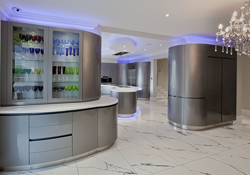 This is an example of a large u-shaped enclosed kitchen in London with an integrated sink, flat-panel cabinets, grey cabinets, composite countertops, stainless steel appliances, marble flooring and an island.