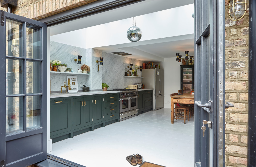 ロンドンにあるトラディショナルスタイルのおしゃれなキッチン (シェーカースタイル扉のキャビネット、緑のキャビネット、白いキッチンパネル、石スラブのキッチンパネル、シルバーの調理設備、塗装フローリング、アイランドなし、白い床、白いキッチンカウンター) の写真