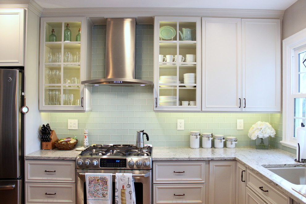Bild på ett mellanstort vintage l-kök, med luckor med infälld panel, granitbänkskiva, vita skåp, rostfria vitvaror, en undermonterad diskho, blått stänkskydd och stänkskydd i glaskakel