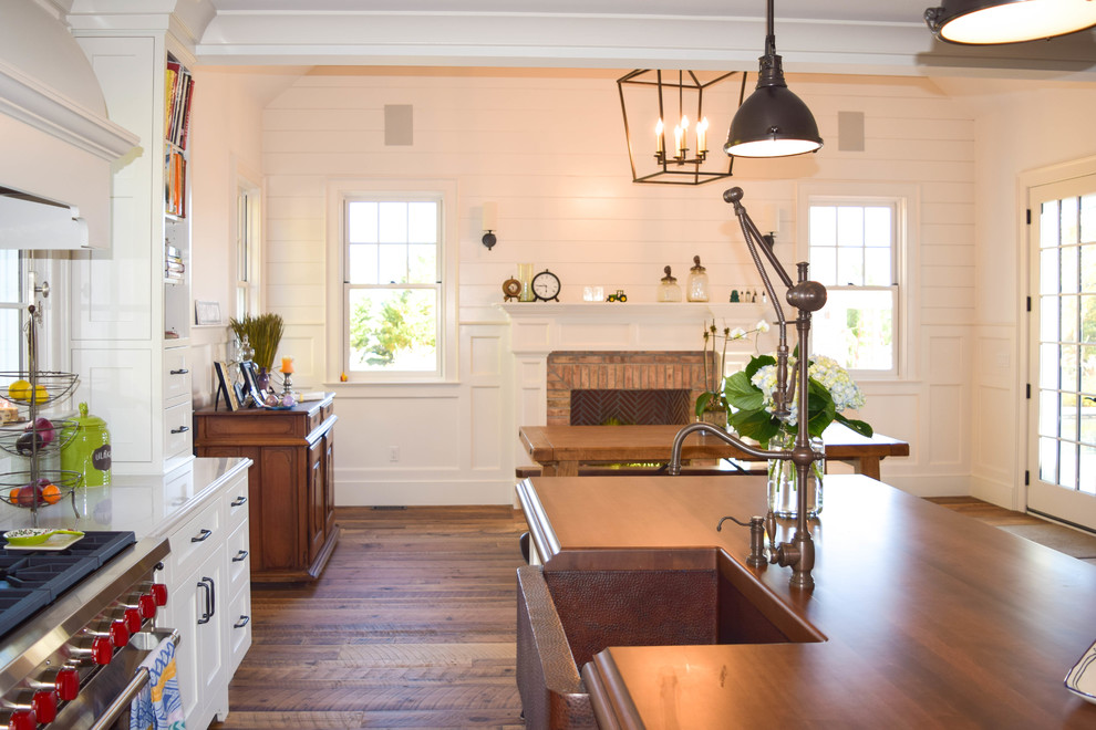 Exempel på ett stort lantligt kök, med en rustik diskho, luckor med infälld panel, vita skåp, träbänkskiva, blått stänkskydd, stänkskydd i glaskakel, rostfria vitvaror, mellanmörkt trägolv och en köksö