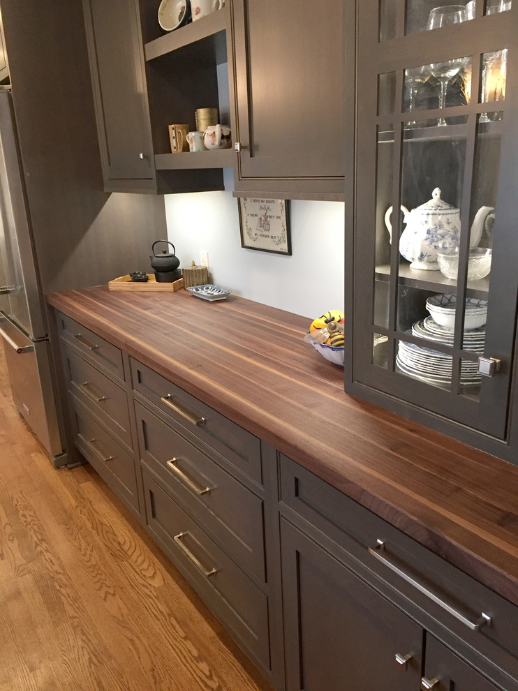 Mid-sized eclectic galley medium tone wood floor and brown floor enclosed kitchen photo in Milwaukee with an undermount sink, shaker cabinets, gray cabinets, wood countertops, white backsplash, ceramic backsplash, stainless steel appliances and no island