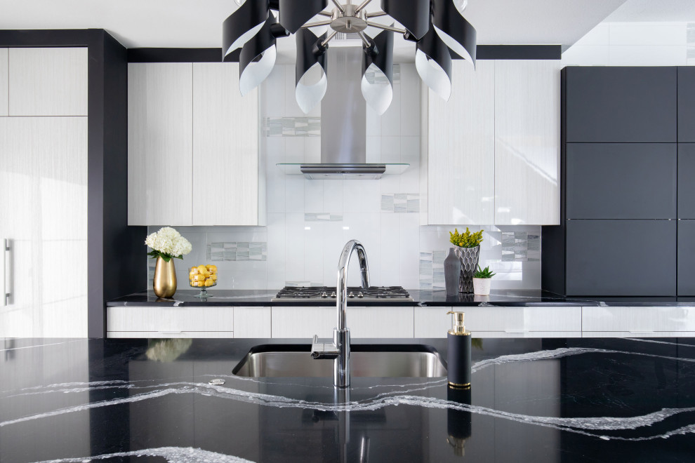 Zweizeilige Moderne Küche mit flächenbündigen Schrankfronten, weißen Schränken, Granit-Arbeitsplatte, Küchenrückwand in Weiß, Küchengeräten aus Edelstahl, braunem Holzboden, Kücheninsel, buntem Boden und schwarzer Arbeitsplatte in Houston