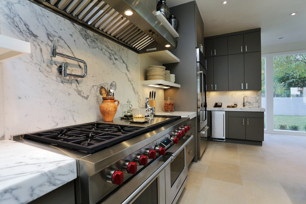Ejemplo de cocina contemporánea con encimera de mármol, salpicadero blanco, electrodomésticos de acero inoxidable y una isla