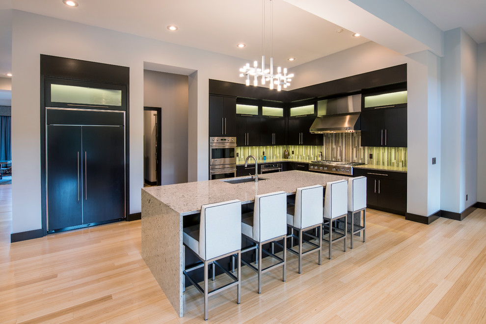 Inspiration for a large modern l-shaped bamboo floor open concept kitchen remodel in Other with an undermount sink, flat-panel cabinets, dark wood cabinets, quartz countertops, an island, green backsplash, glass tile backsplash and paneled appliances