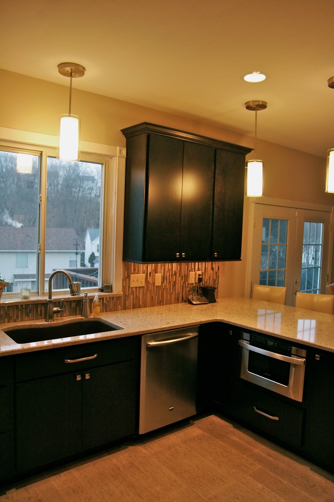 Moderne Wohnküche in U-Form mit flächenbündigen Schrankfronten, dunklen Holzschränken, Granit-Arbeitsplatte, Küchengeräten aus Edelstahl und Porzellan-Bodenfliesen in St. Louis