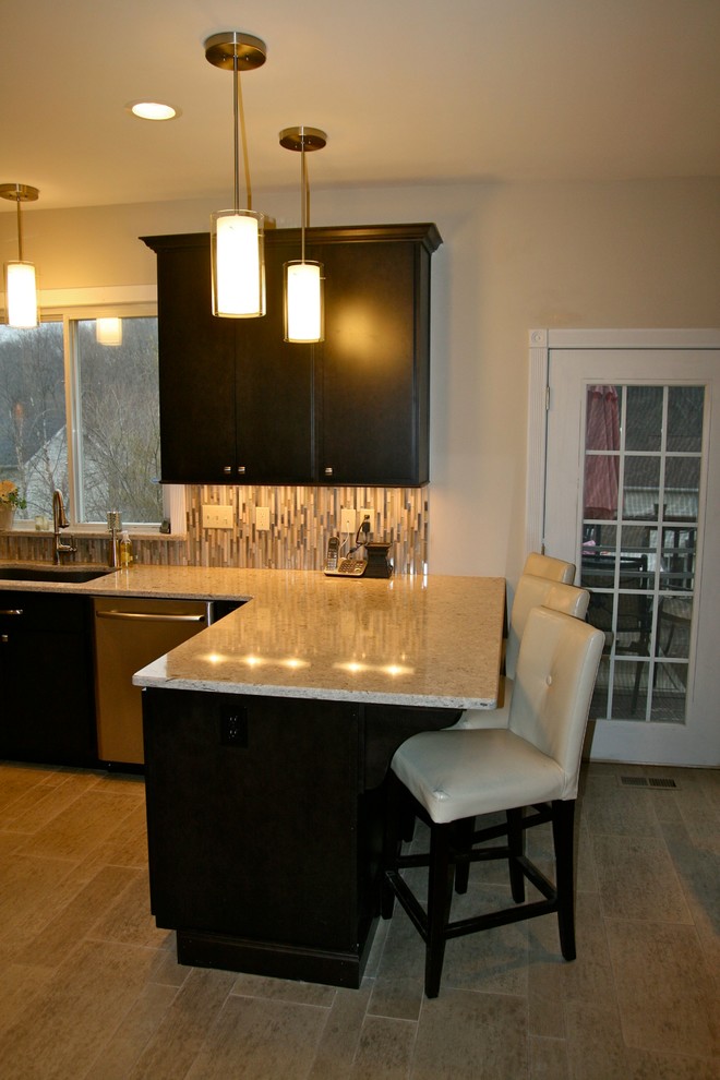 Moderne Wohnküche in U-Form mit flächenbündigen Schrankfronten, dunklen Holzschränken, Granit-Arbeitsplatte, Küchengeräten aus Edelstahl und Porzellan-Bodenfliesen in St. Louis