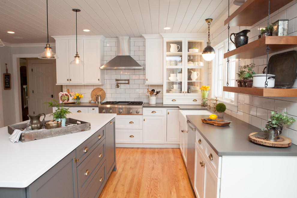 Exempel på ett mellanstort klassiskt kök, med en rustik diskho, luckor med infälld panel, vita skåp, bänkskiva i kvarts, flerfärgad stänkskydd, stänkskydd i tunnelbanekakel, rostfria vitvaror, ljust trägolv och en köksö