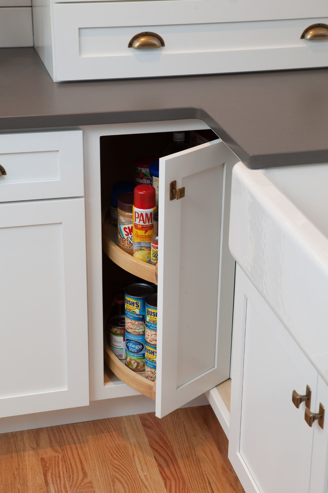 Inspiration for a mid-sized transitional u-shaped light wood floor eat-in kitchen remodel in Chicago with a farmhouse sink, recessed-panel cabinets, white cabinets, quartz countertops, multicolored backsplash, subway tile backsplash, stainless steel appliances and an island