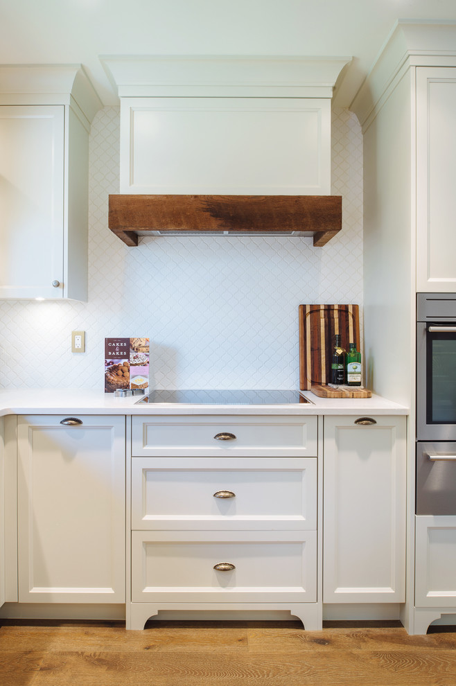 Example of a mid-sized cottage chic u-shaped medium tone wood floor open concept kitchen design in Vancouver with an undermount sink, shaker cabinets, white cabinets, quartz countertops, white backsplash, mosaic tile backsplash, paneled appliances and no island