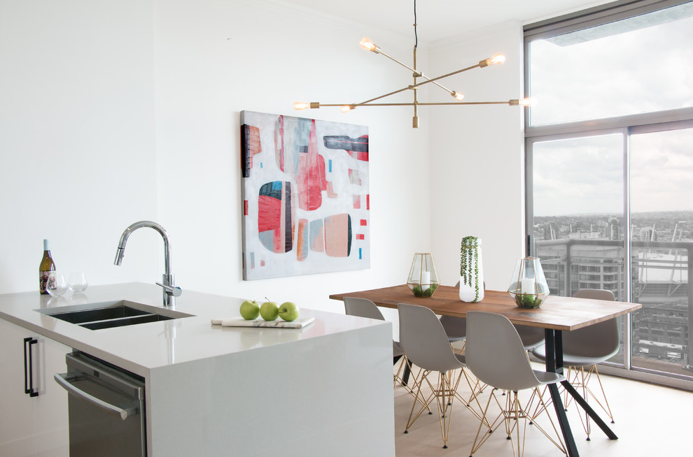 Imagen de cocina comedor retro de tamaño medio con salpicadero de azulejos tipo metro, electrodomésticos de acero inoxidable, suelo de madera clara y una isla