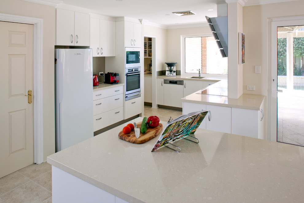 Immagine di una cucina moderna con ante lisce, ante bianche, top in quarzo composito, paraspruzzi marrone, paraspruzzi con lastra di vetro e top beige