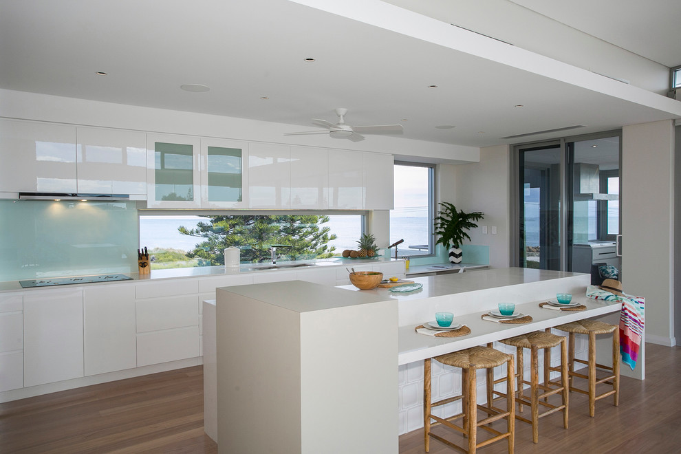 Zweizeilige Küche mit Unterbauwaschbecken, Quarzwerkstein-Arbeitsplatte, Glasrückwand, hellem Holzboden und Kücheninsel in Perth